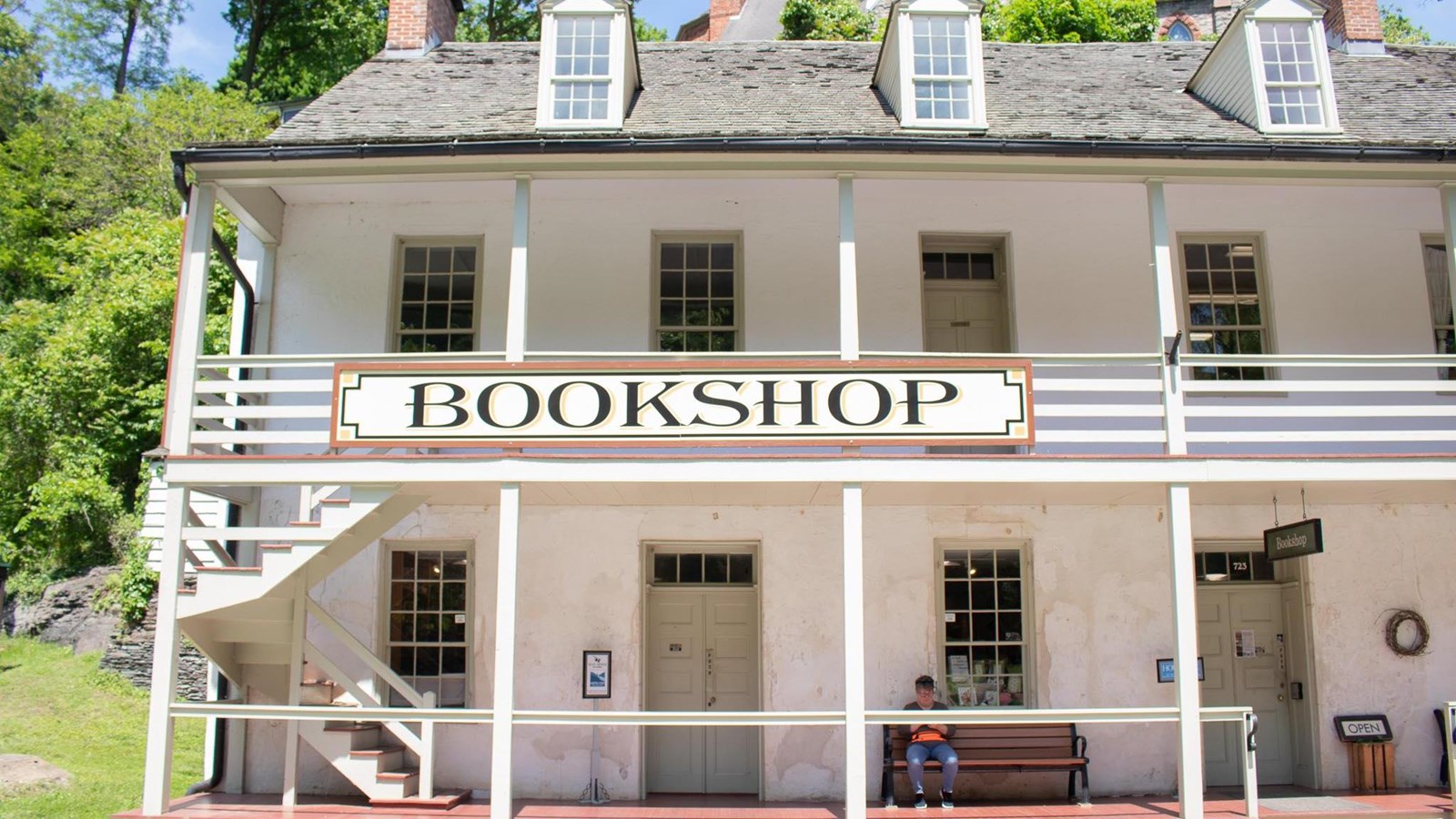 Two story rectangular building with double porches and sign: Bookshop.