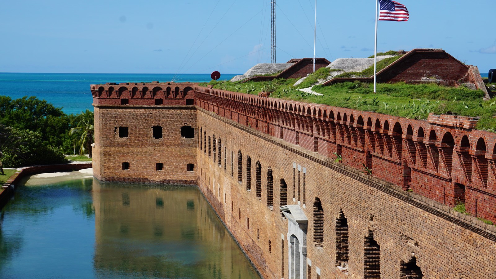 A brick fort is surrounded by a moat and blue sky