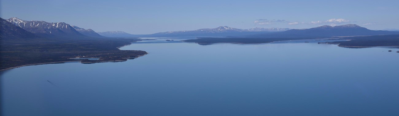 An aerial view of an island in the blue waters of Lake Clark