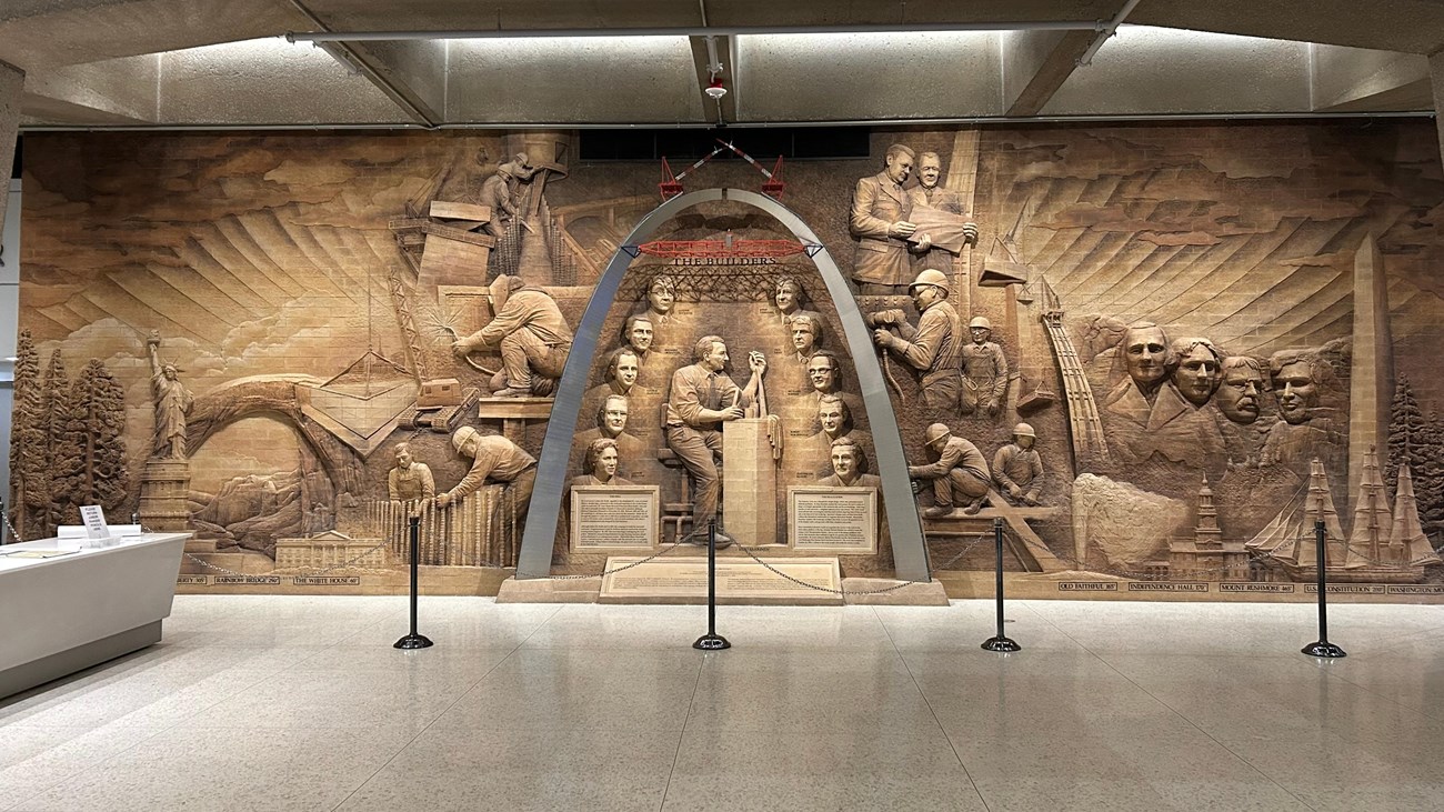 A steel arch with several carved figures inside and around it