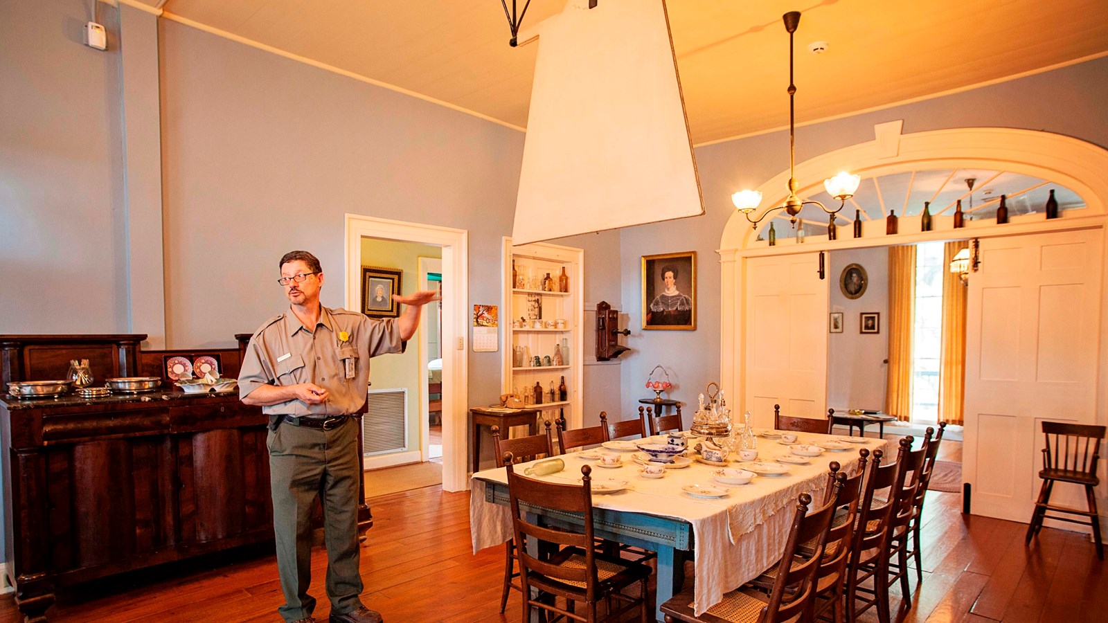 A ranger stands beside the table in the dining room.