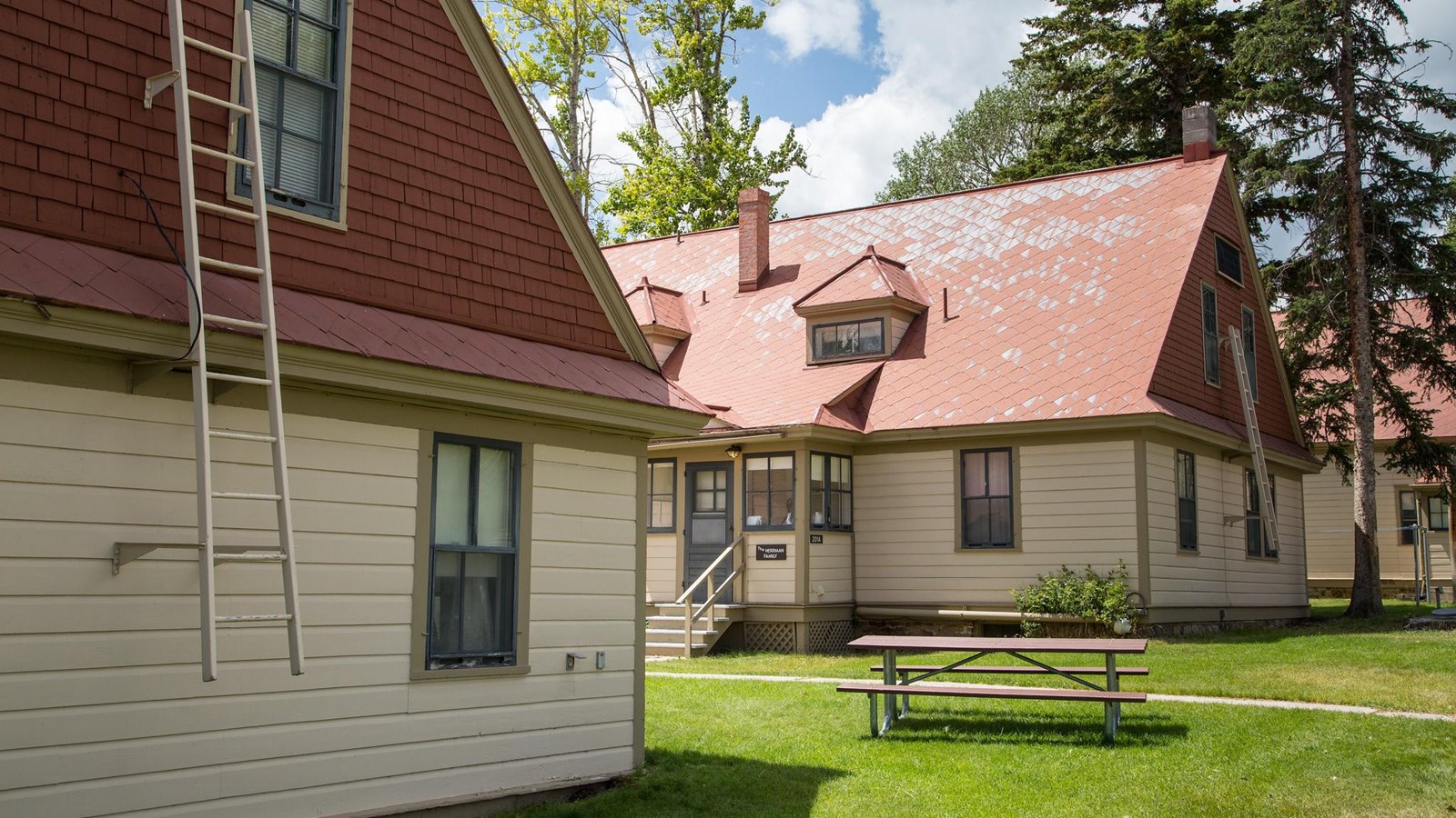 Historic buildings with pale siding and red roof shingles.