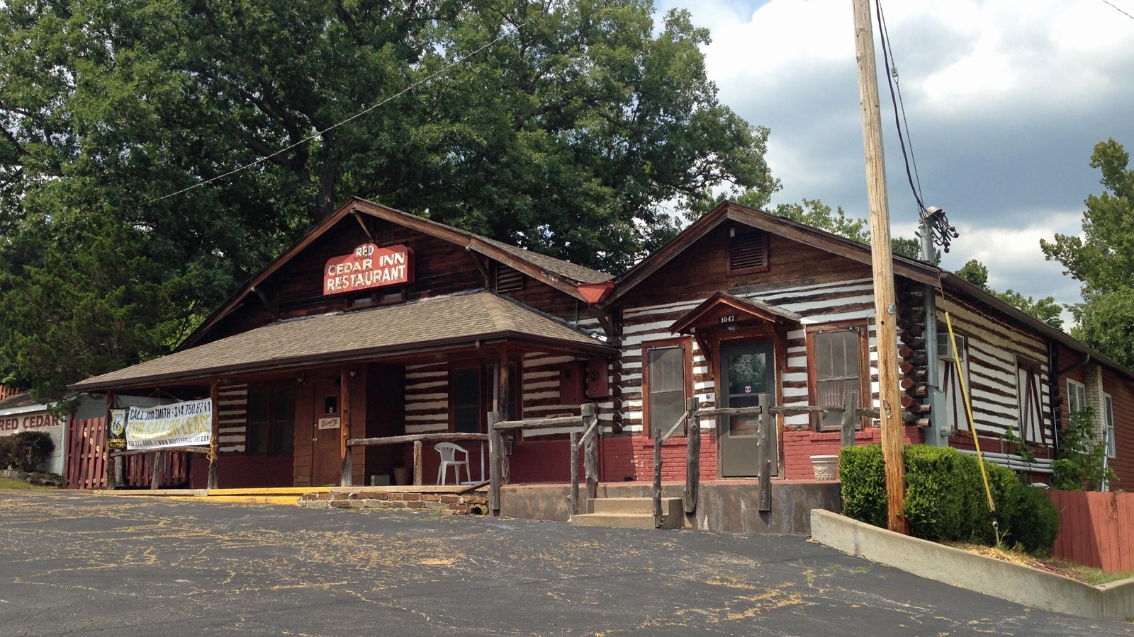 A log building with red trim and a sign that reads