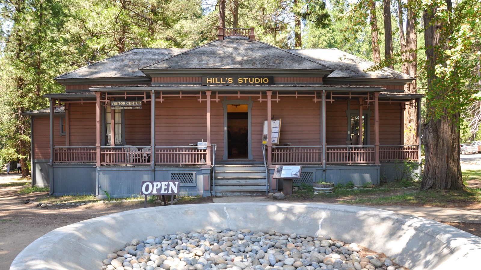 A building with a covered porch, a sign over the door reads 