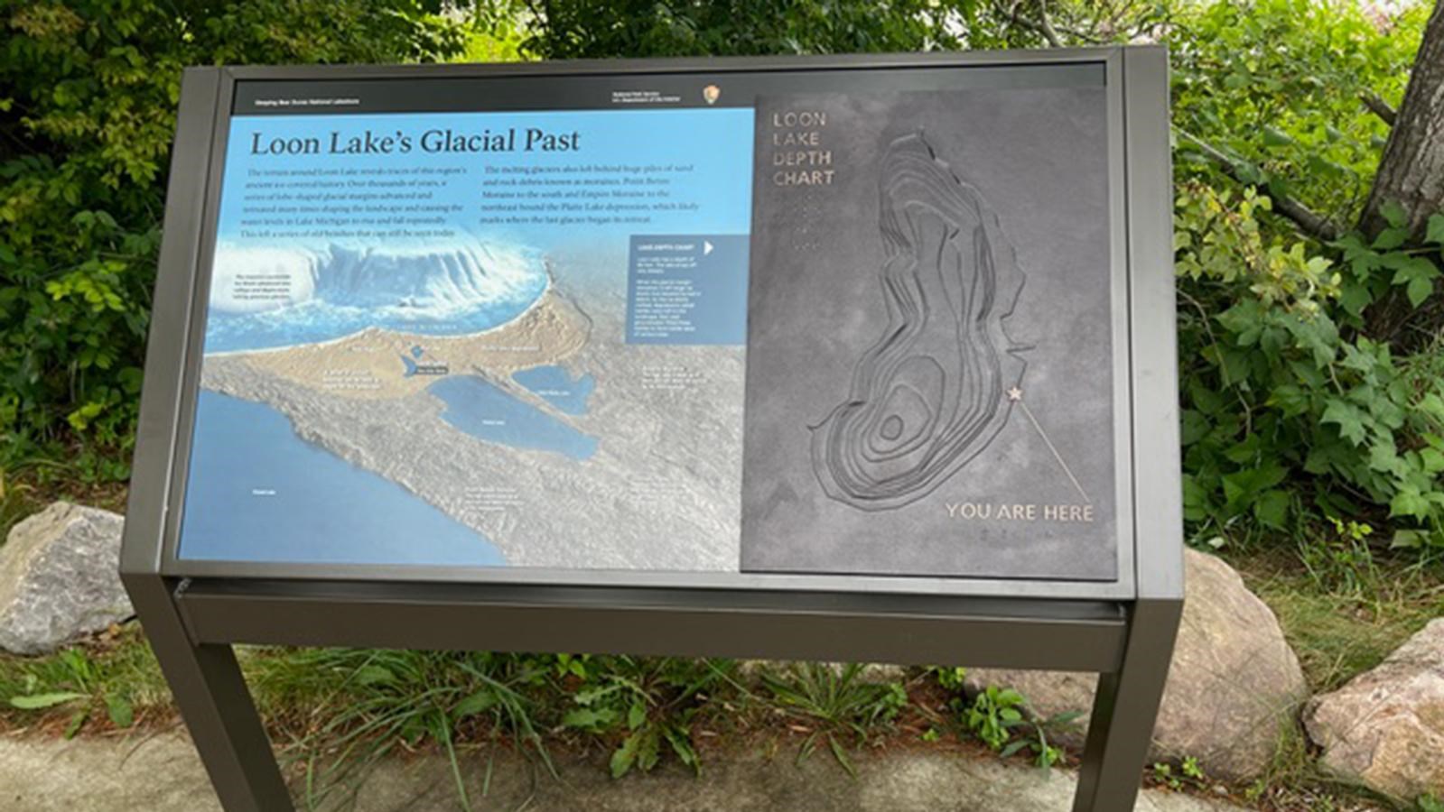 A wayside with a bronze tactile of a lake. Full audio description in description.