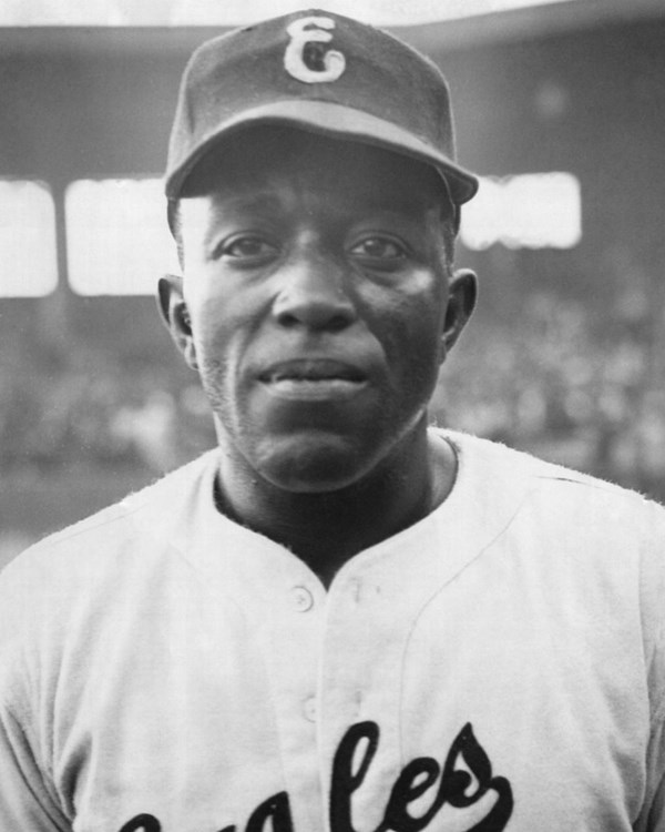 African American man in baseball uniform that reads "Eagles" on his chest in a baseball stadium