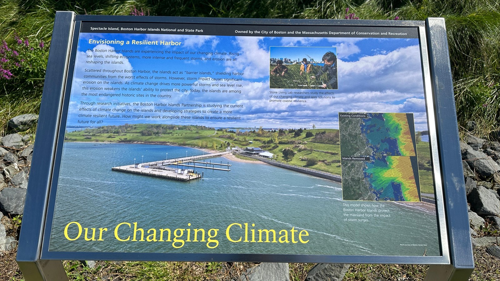 Photo of a metal wayside with a photo of a bright blue sky and ocean