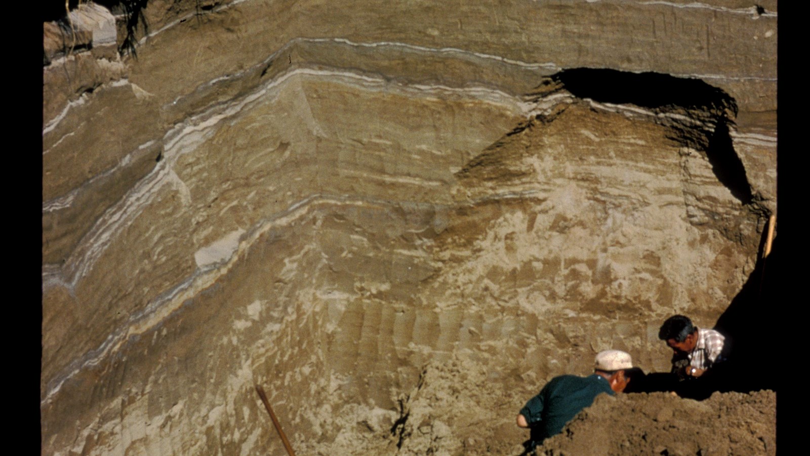 An historic photo of deep archaeological excavation showing many thin layers of strata.