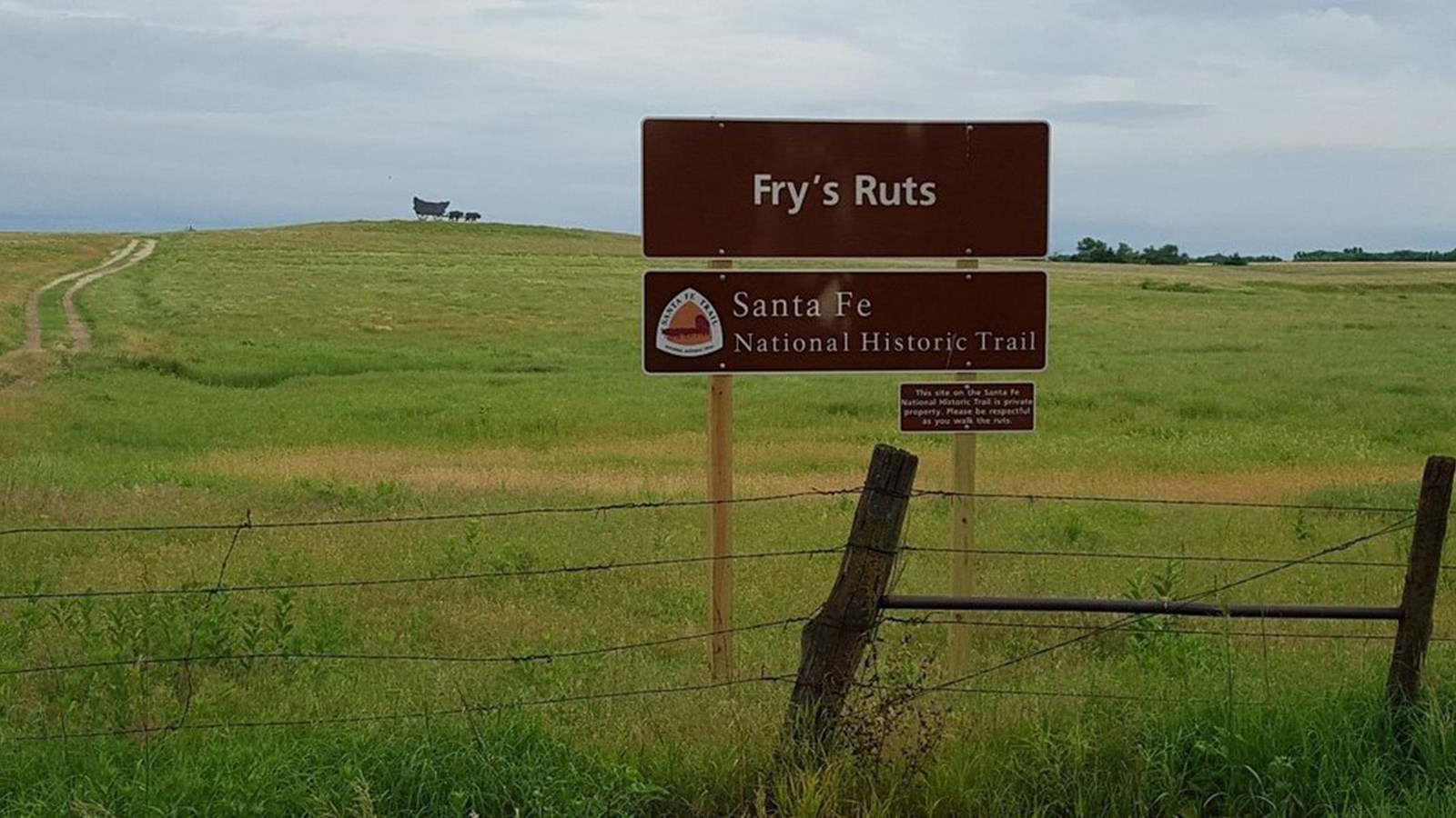 A grassy field with swales from the Santa Fe Trail
