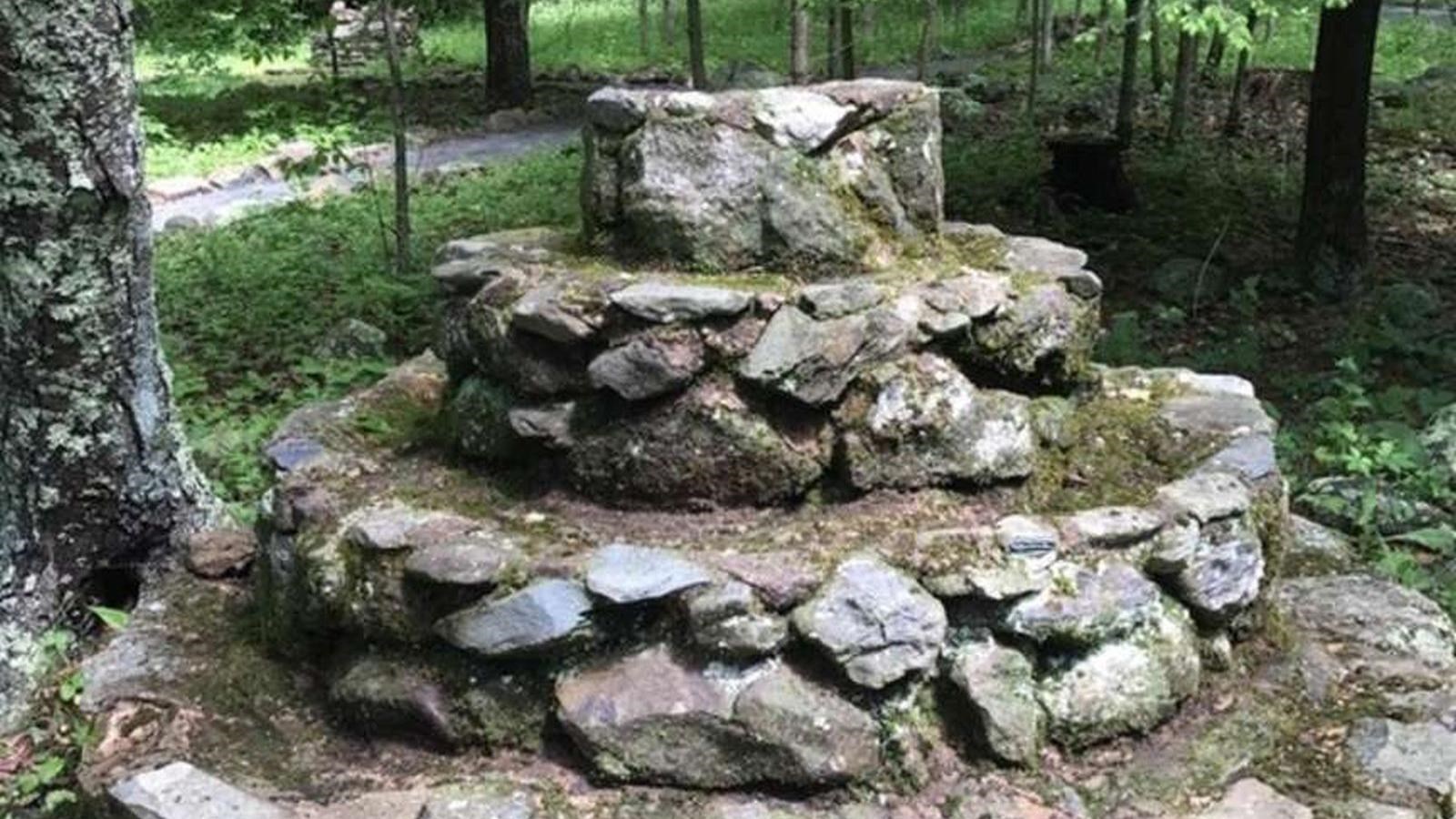 A 4 feet tall structure constructed from stone in 4 round layers,each layer smaller in diameter.