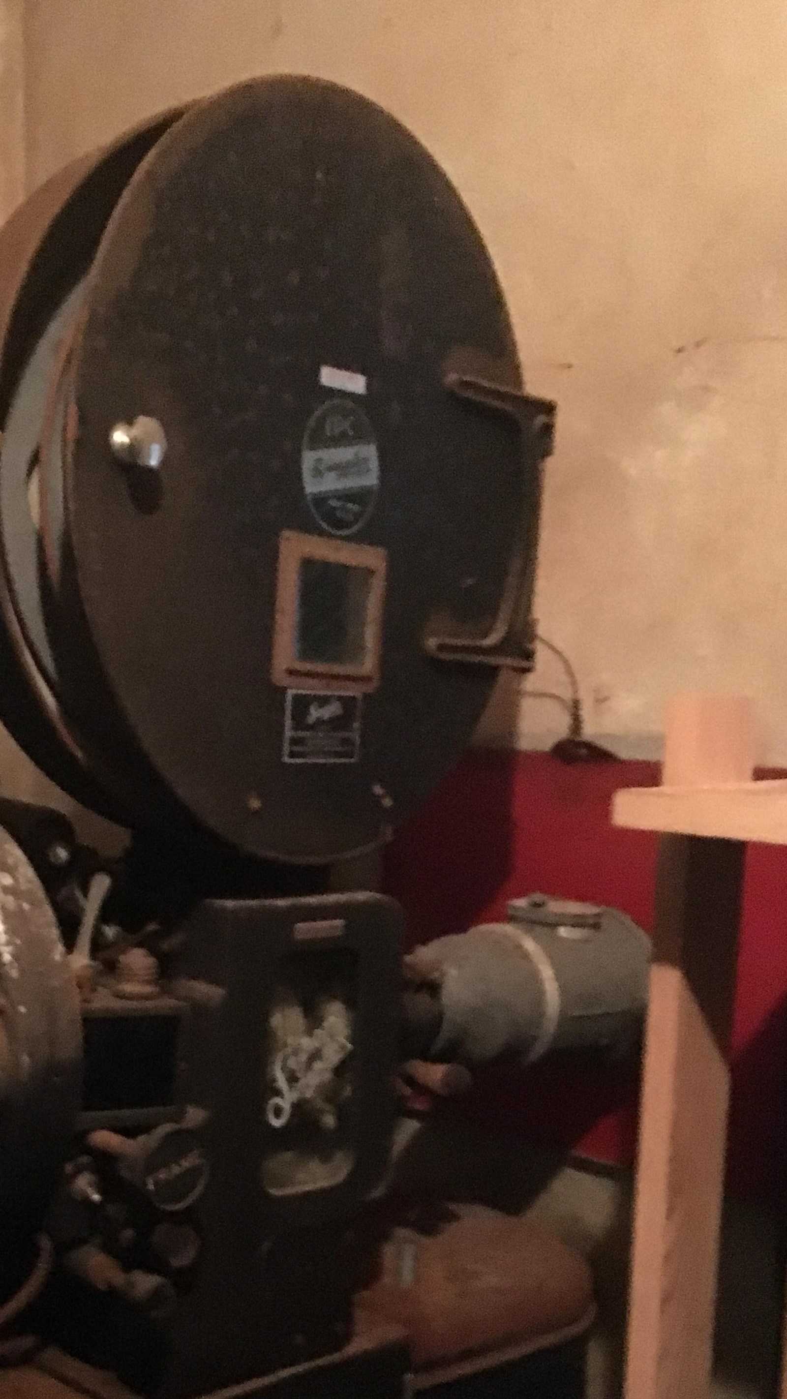 A black film reel in its case on a stand. 