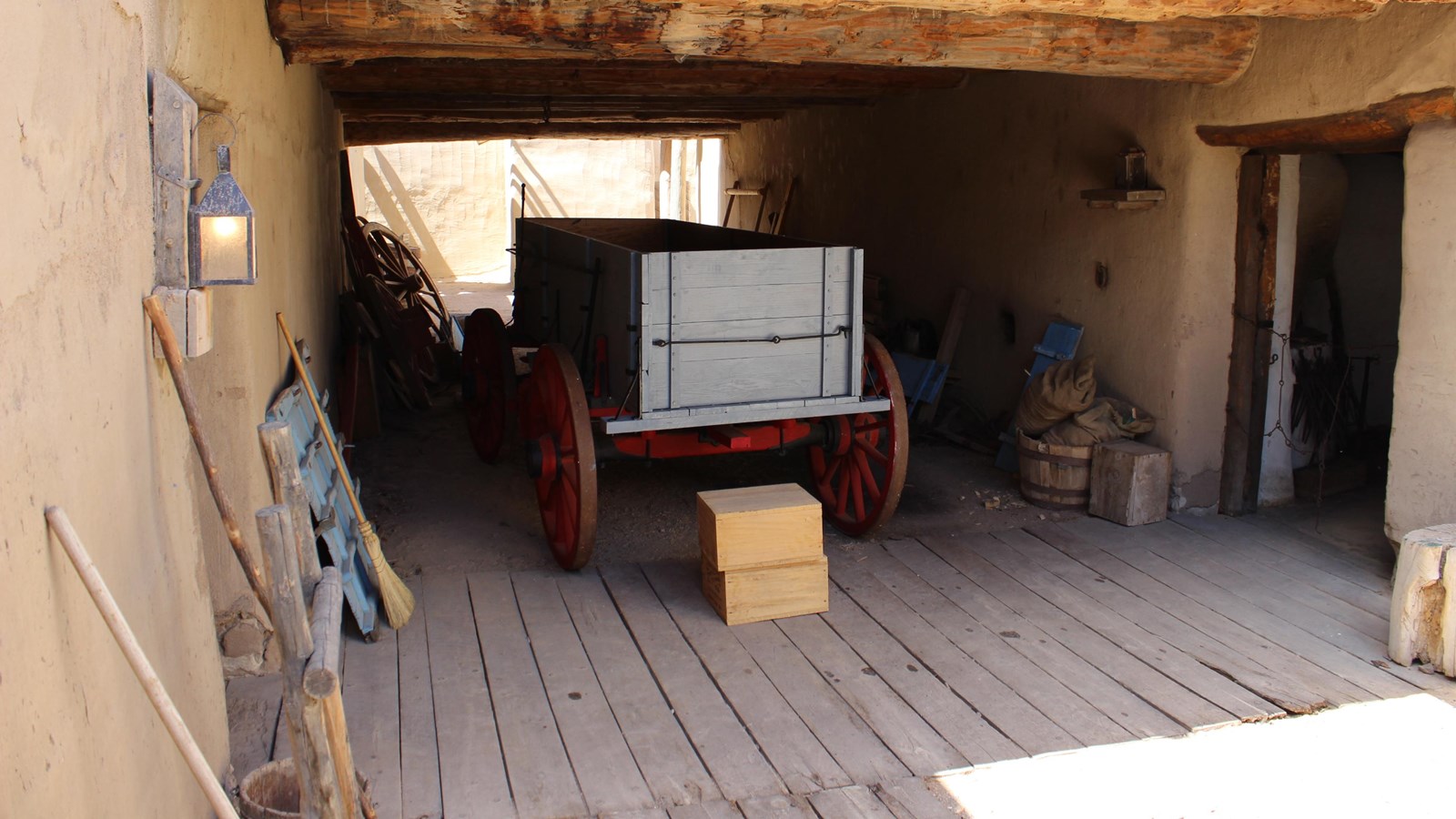A wagon is parked below a room over an alleyway