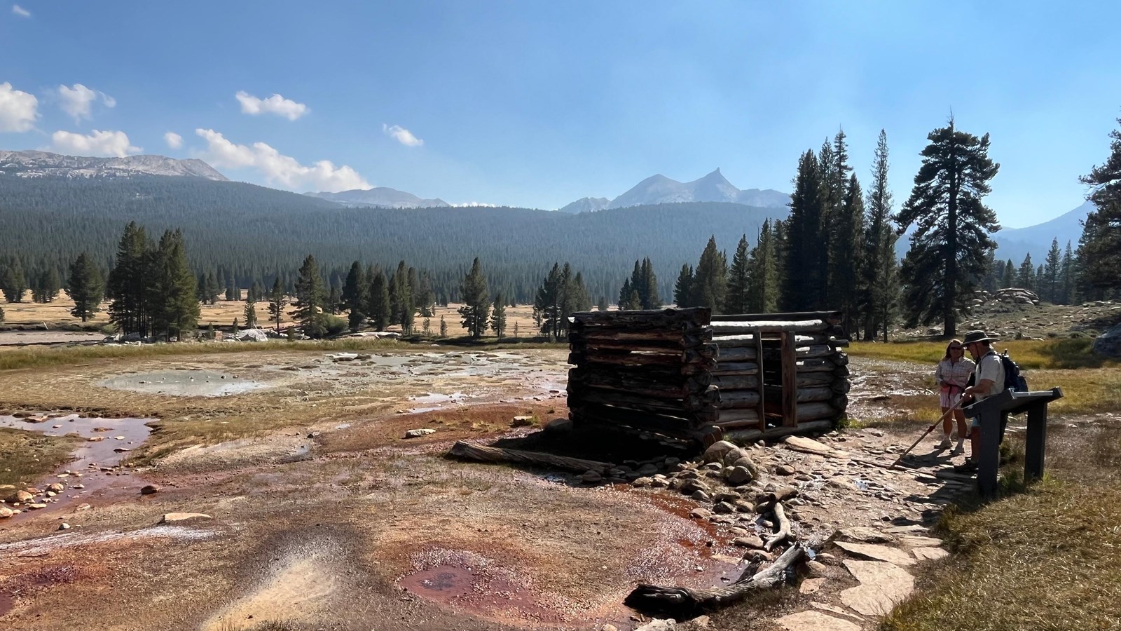 A simple, small log structure surrounded by muddy, reddish waters
