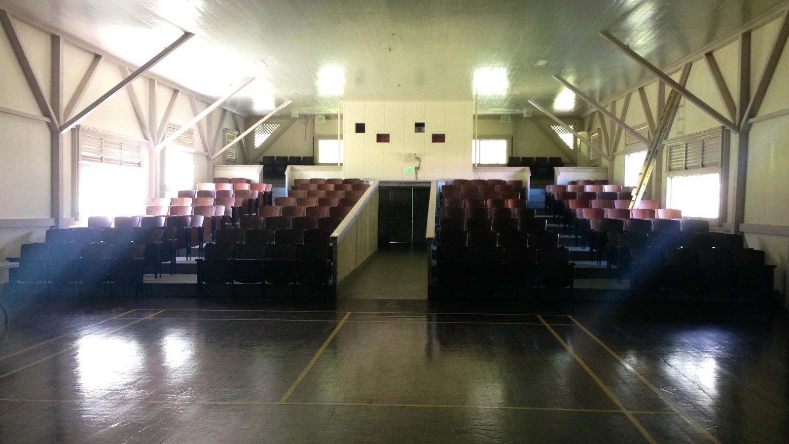 Rows of seats, arranged like a movie-theater, look out towards a large room.