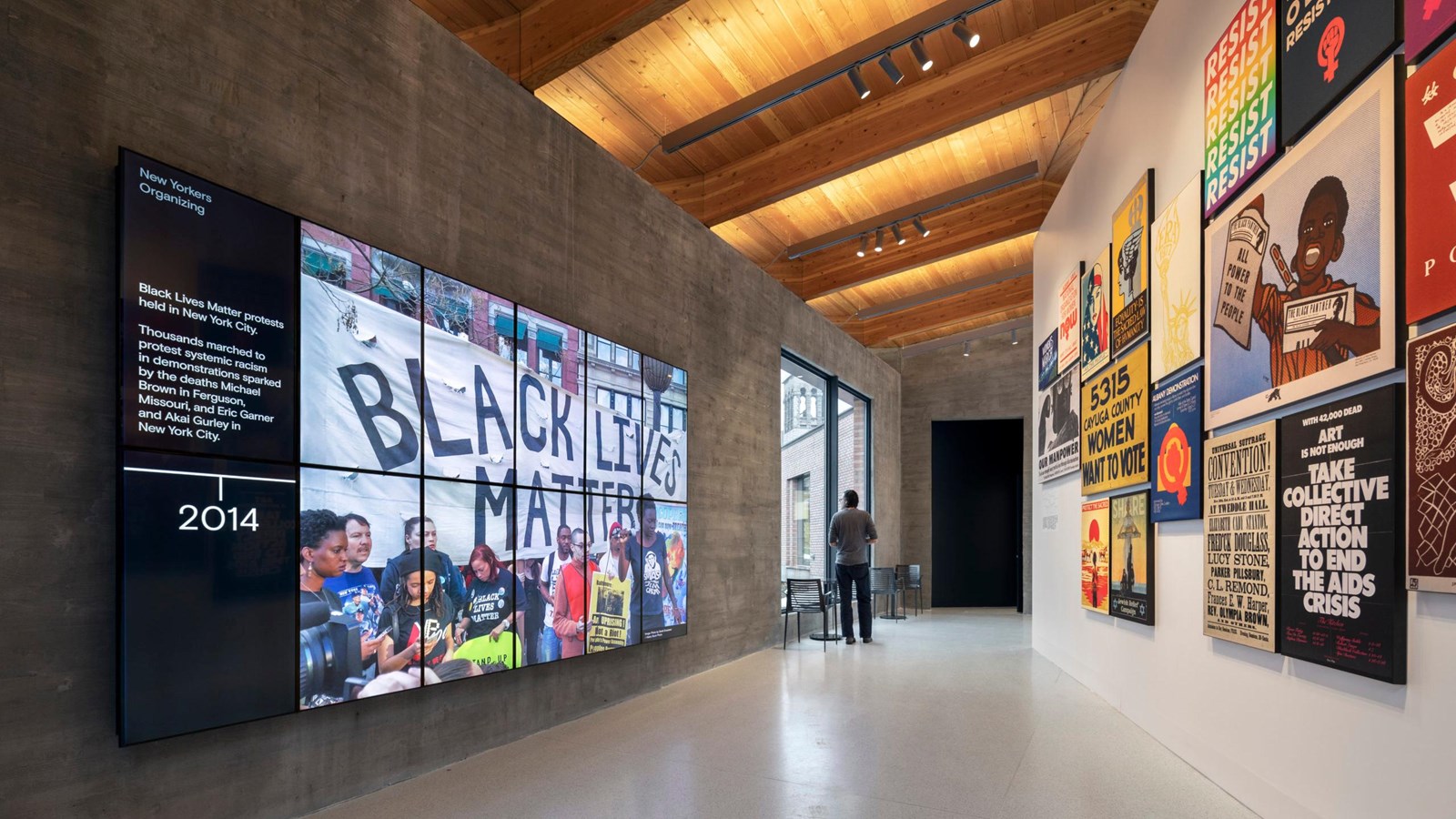 A large room with exhibits and a wall of screens