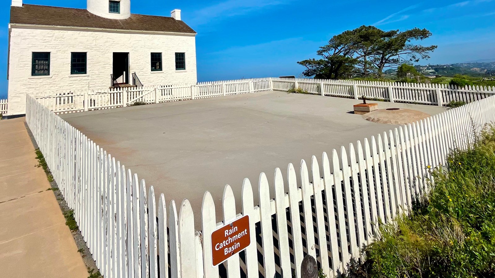 A white fence surrounds a large square area.