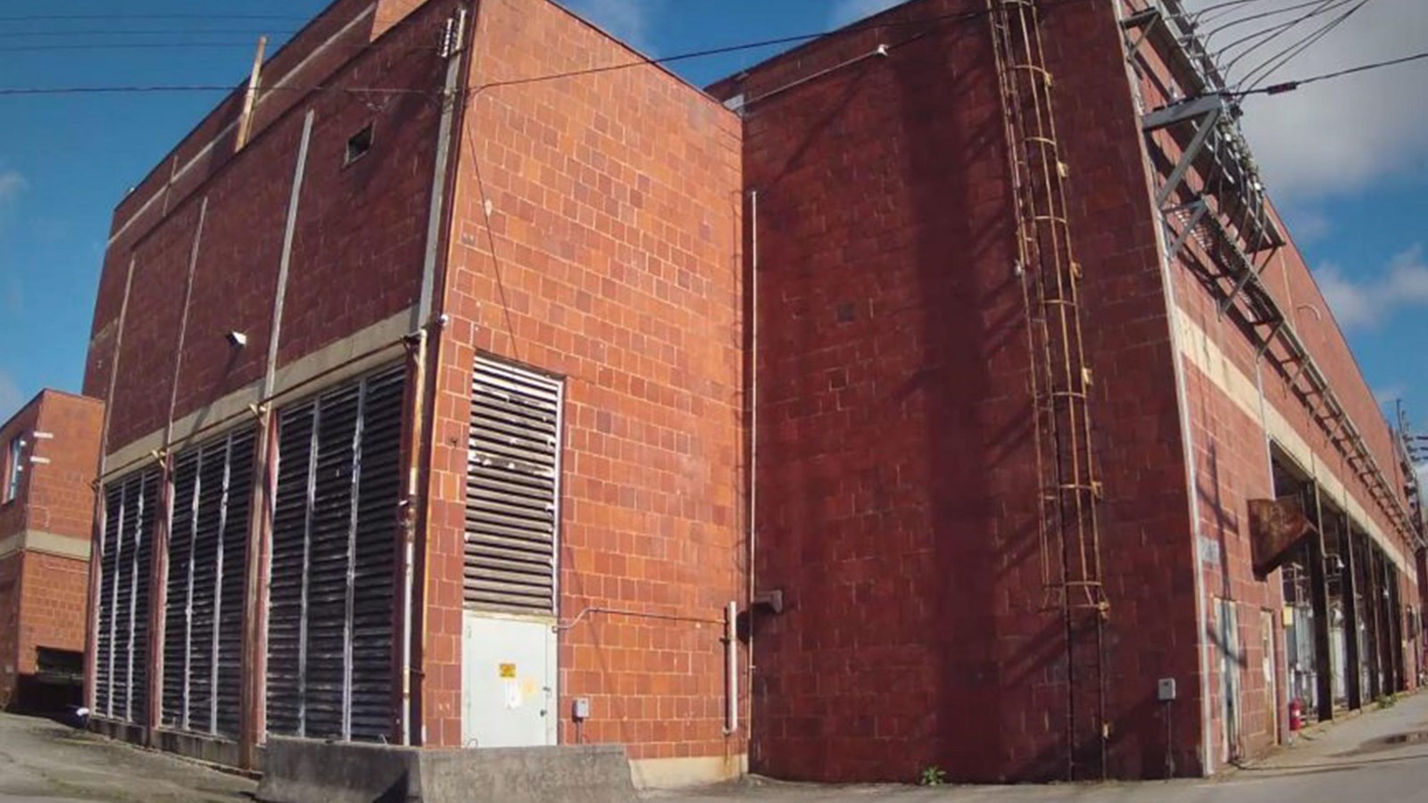A multi-story red brick building with limited windows/doors