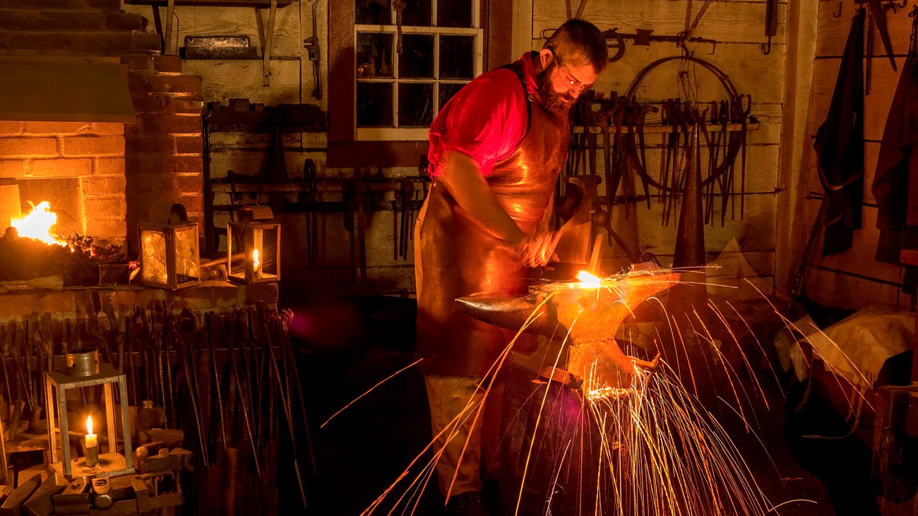 A blacksmith working inside the Blacksmith Shop at Fort Vancouver.