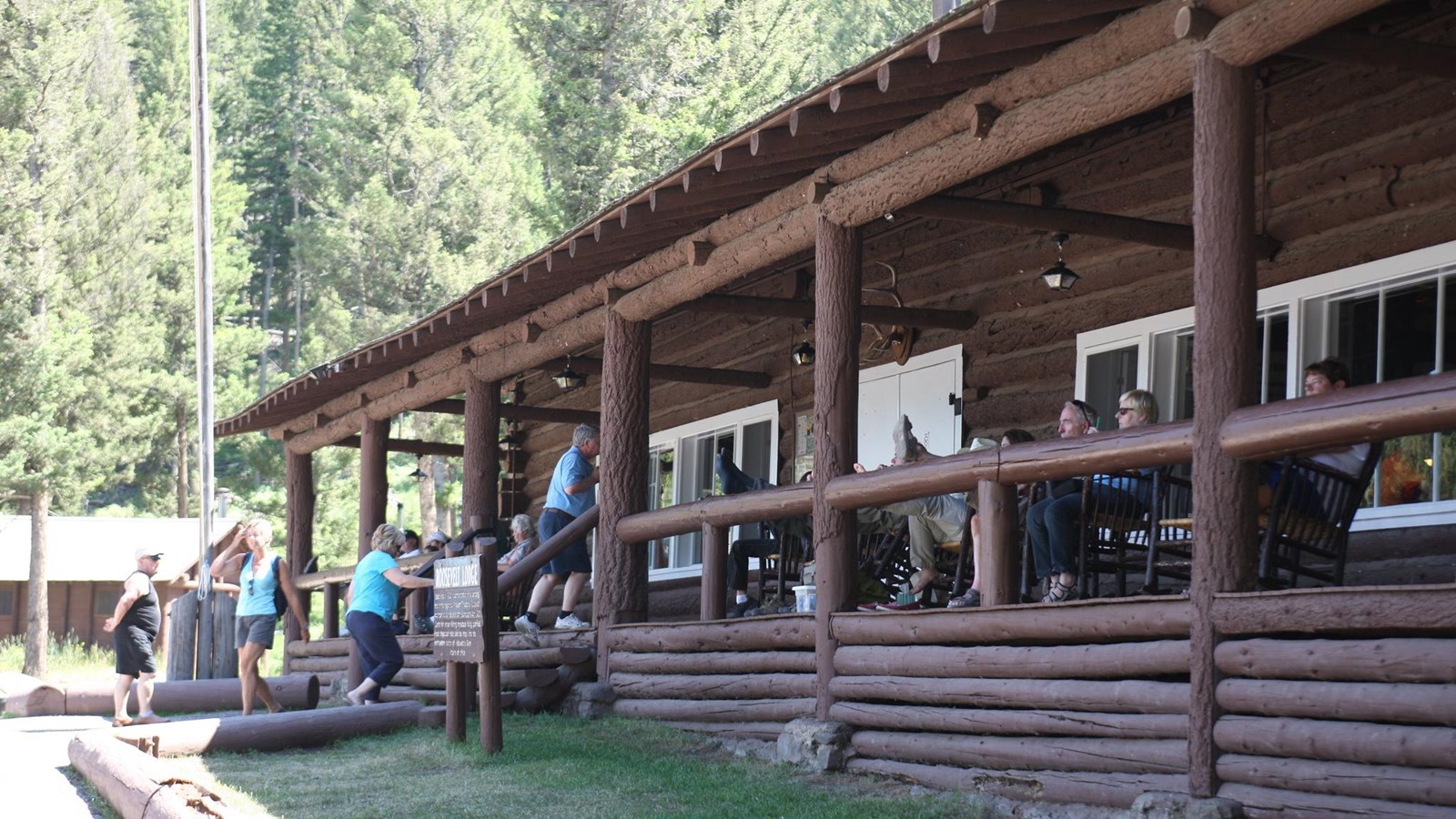 Visitors enjoying the porch of a rustic log building