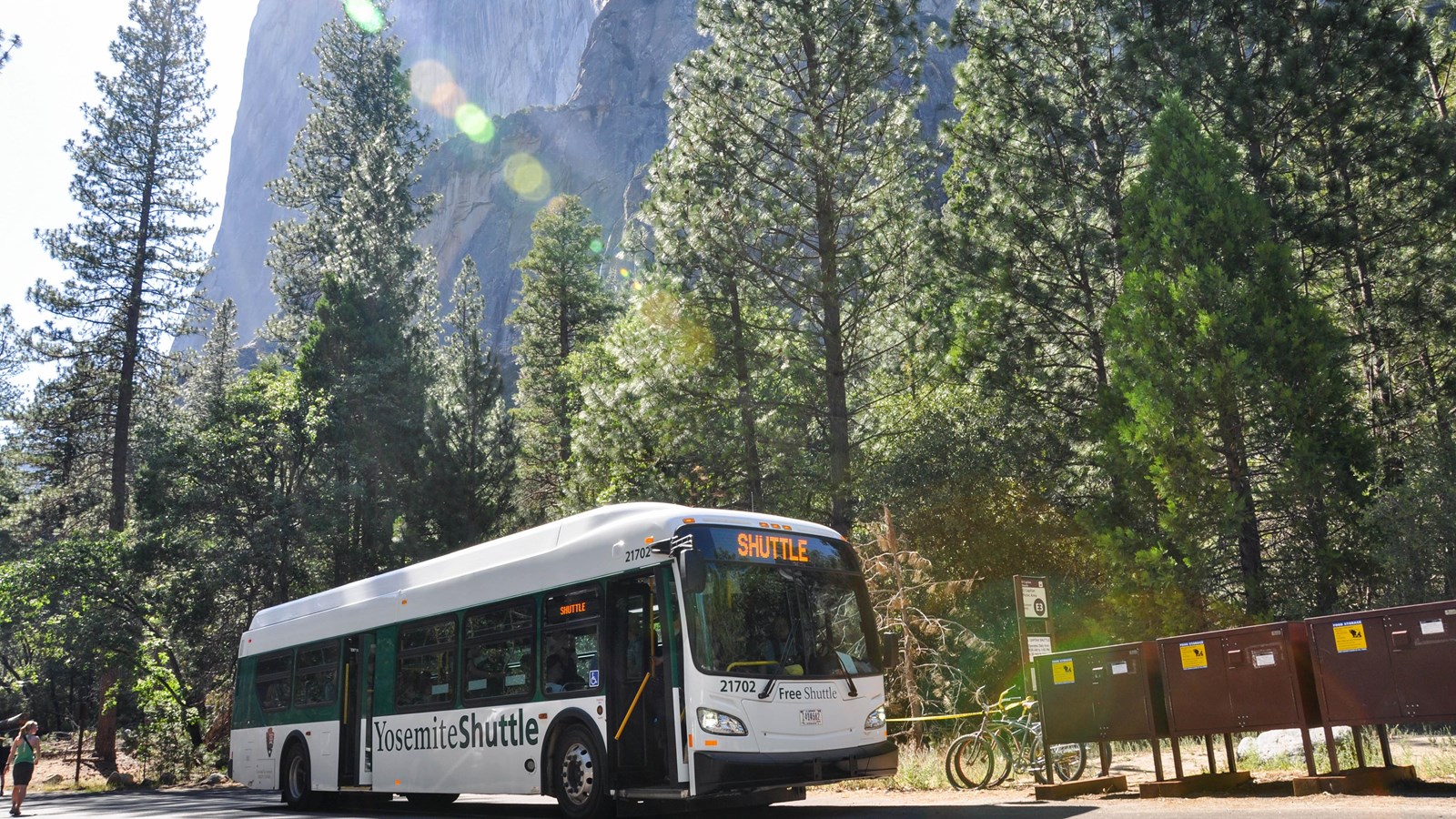 Shuttle bus pulled up to stop near food storage lockers, with El Capitan in the background