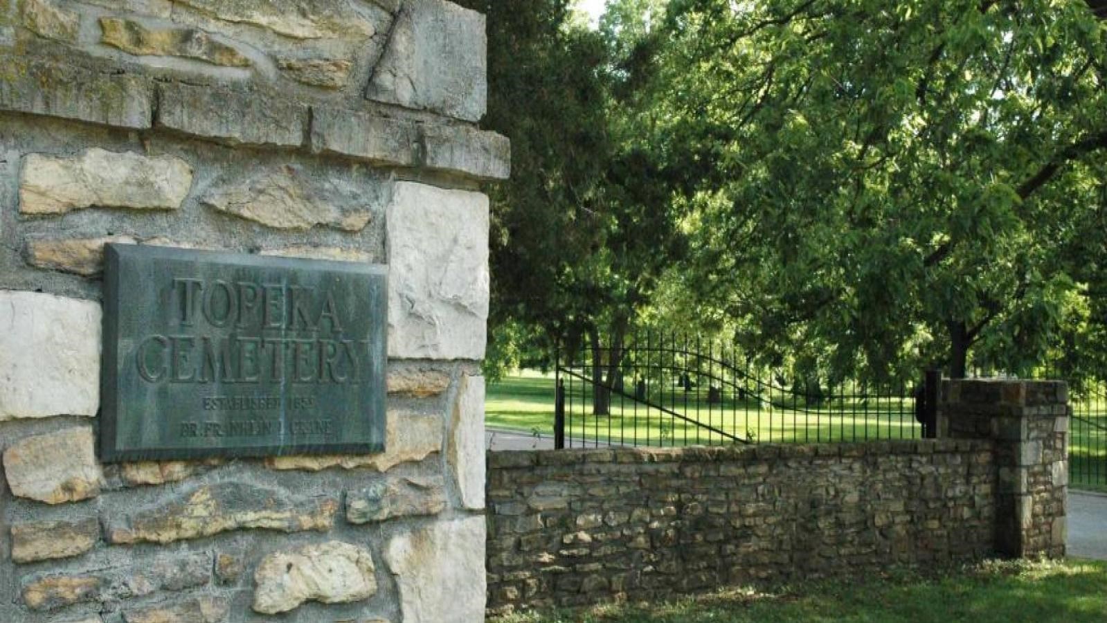 A stone wall with black iron gate can be seen.