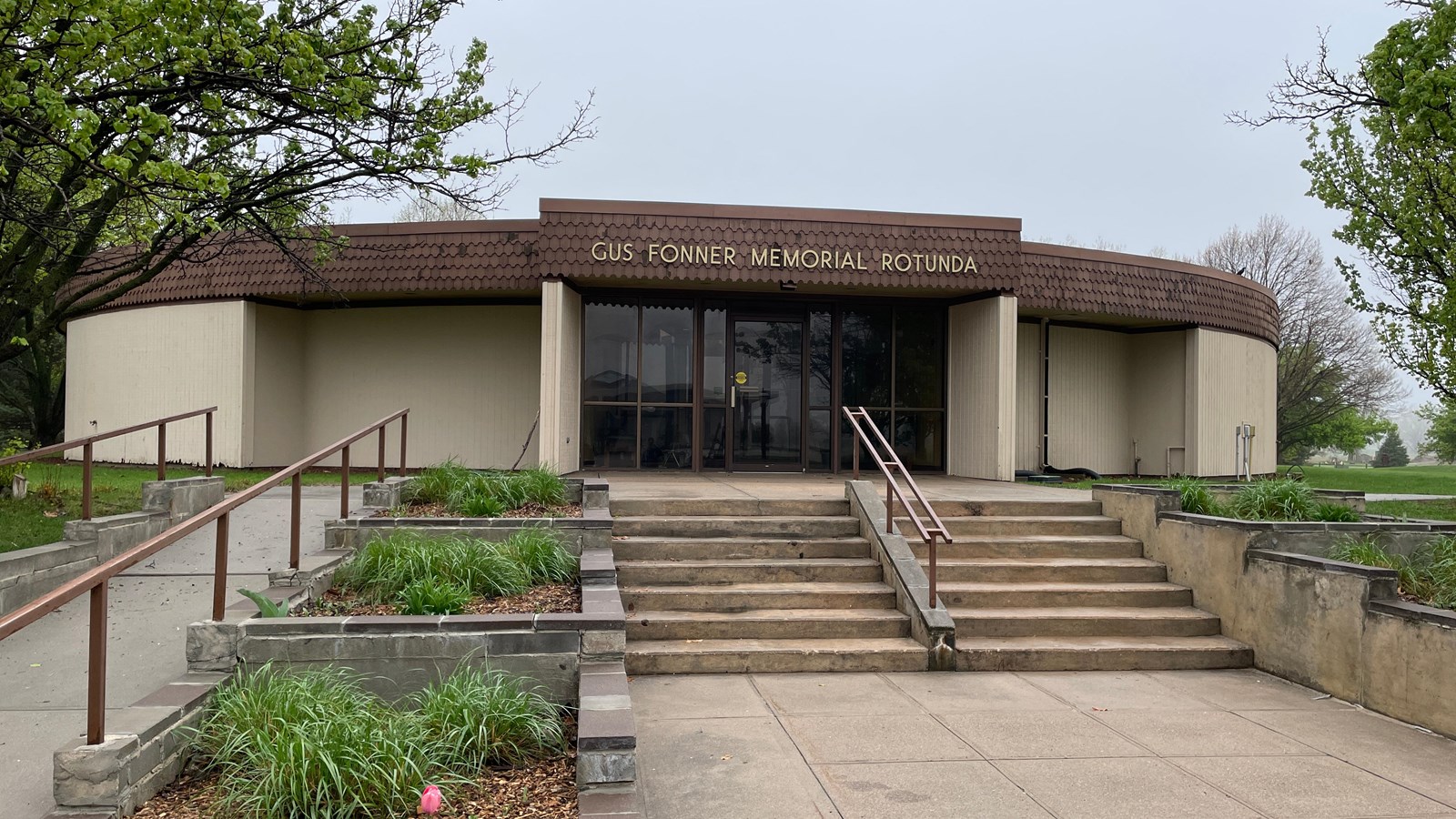 A concrete path with stairs leading to the Gus Fonner Memorial Rotunda.
