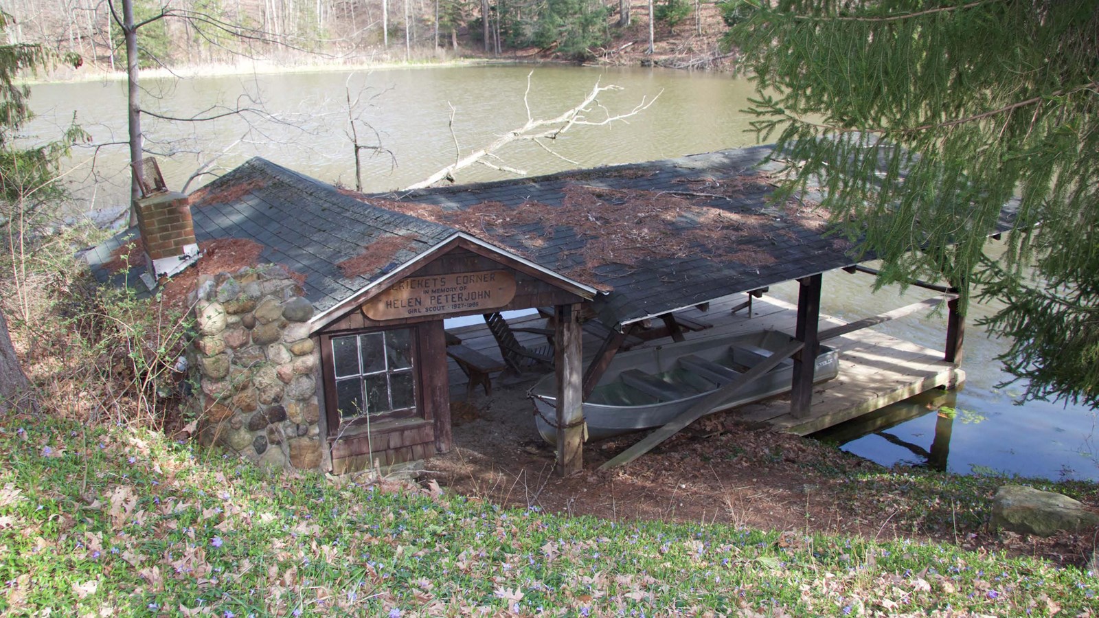 A wood and stone covered boat launch jutting into a lake.