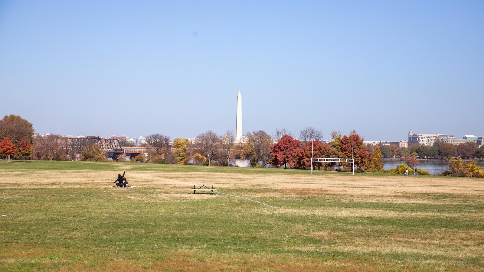A wide open field with the washington monument in the distance