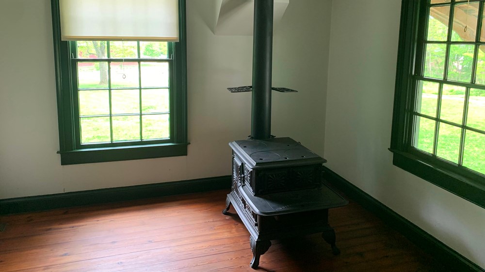 Cast-iron stove displayed between two windows at White Haven