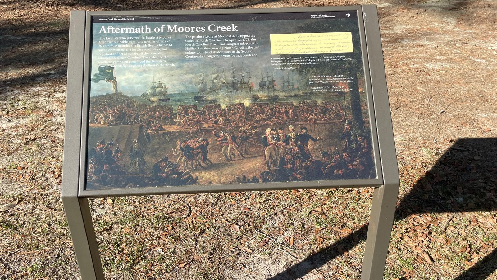 Metal sign and base along the trail with words,