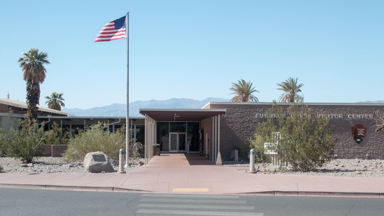 a one story block building and flag pole