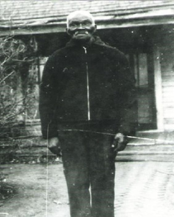 older man standing outside of a house