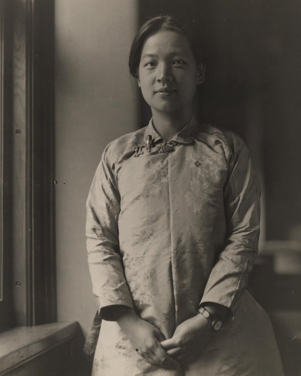 Half-length portrait of Miss Ting, standing by window, facing camera, hands clasped before her