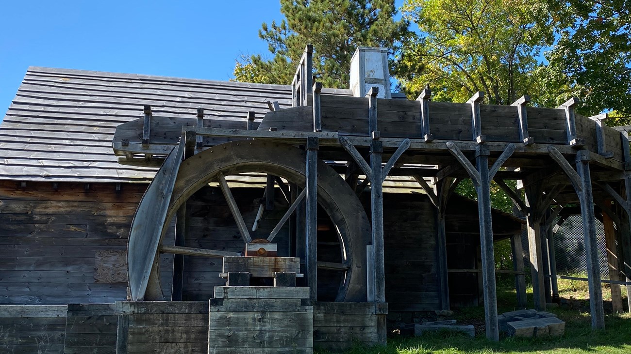 A wooden building with two massive wooden wheels.