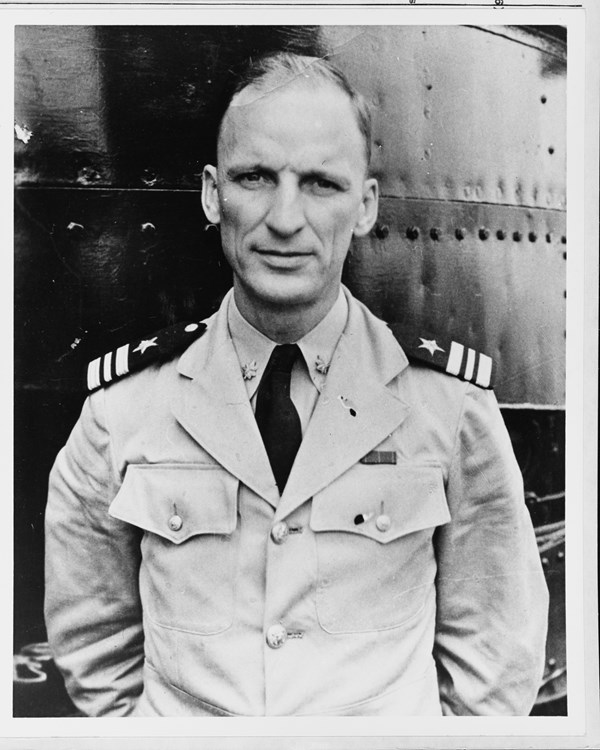 Black and white portrait of a man in a light colored military uniform. 