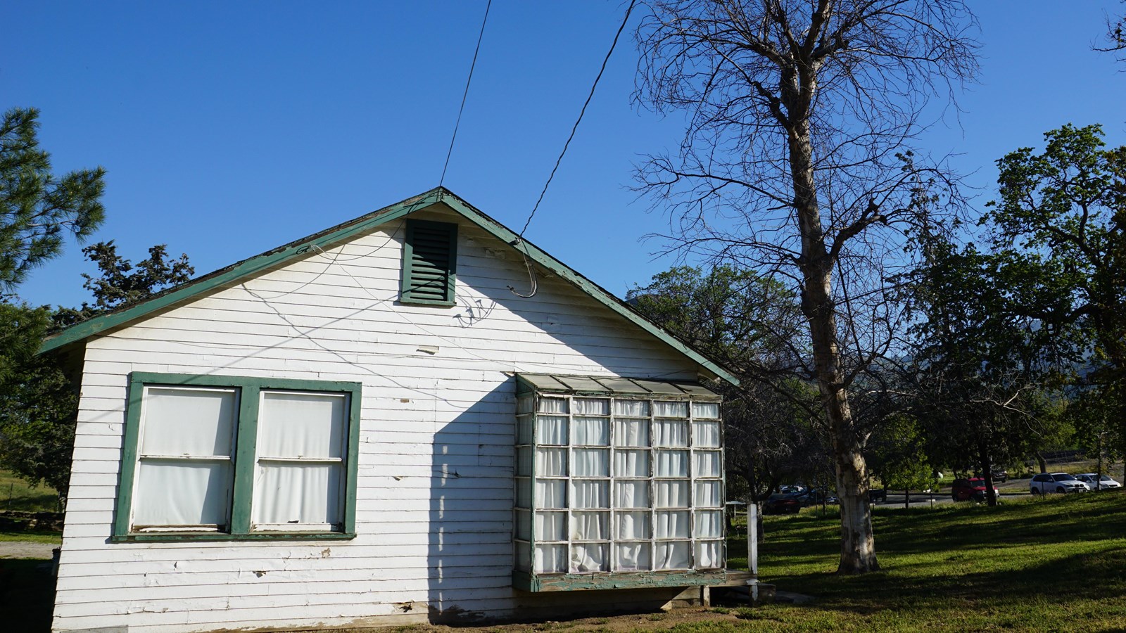 A modest white house with green trim