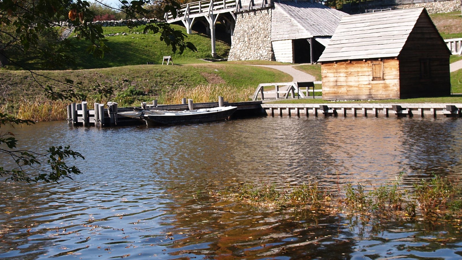 Small single-story building used for storage with wooden dock on the Saugus River