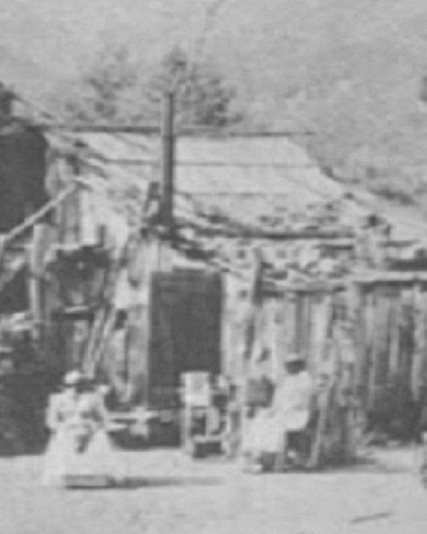 two people sitting outside of a house