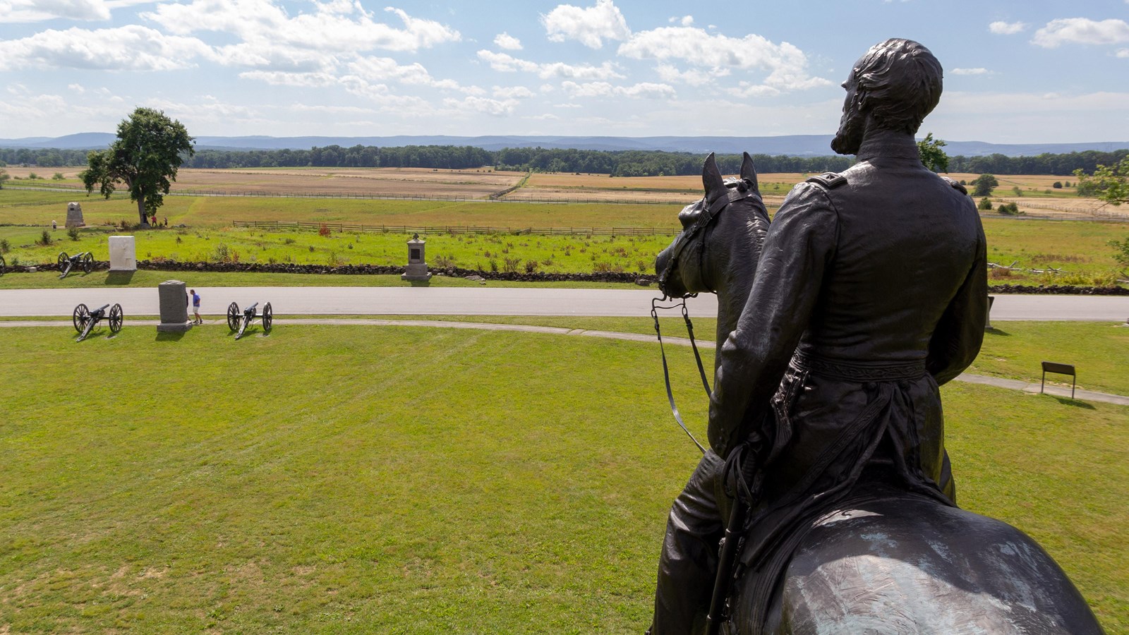 A bronze statue of a general on a horse looking across an open field.