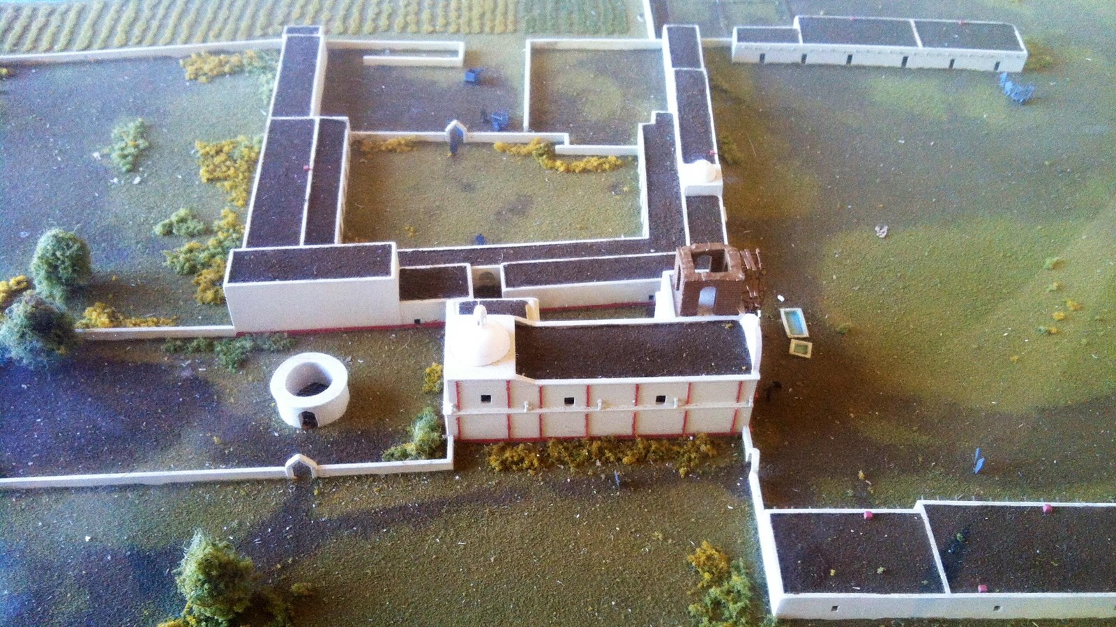 detail of miniature mission community including church, convento buildings, and human figures