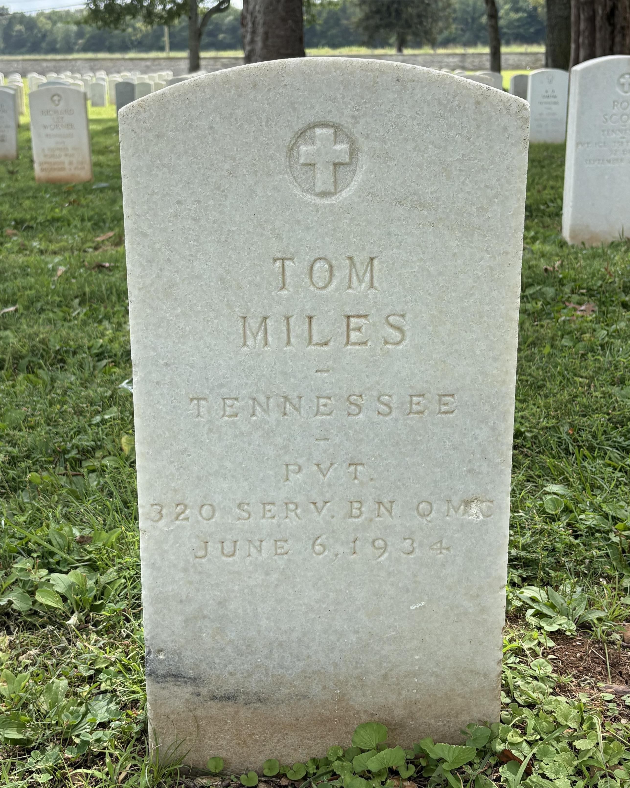 Marble headstone with a cross at the top belonging to WWI veteran Tom Miles.