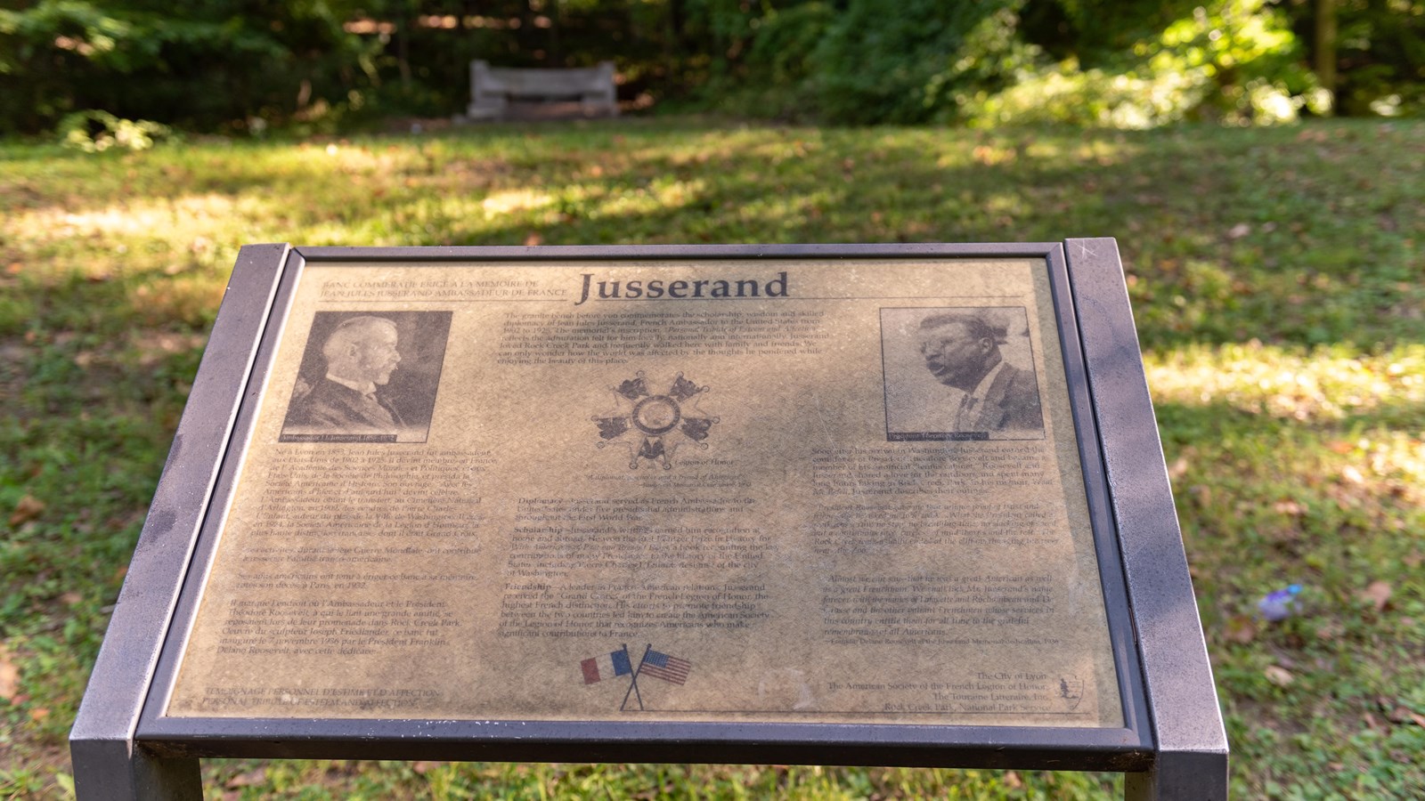 An informational panel in front of a grassy field.