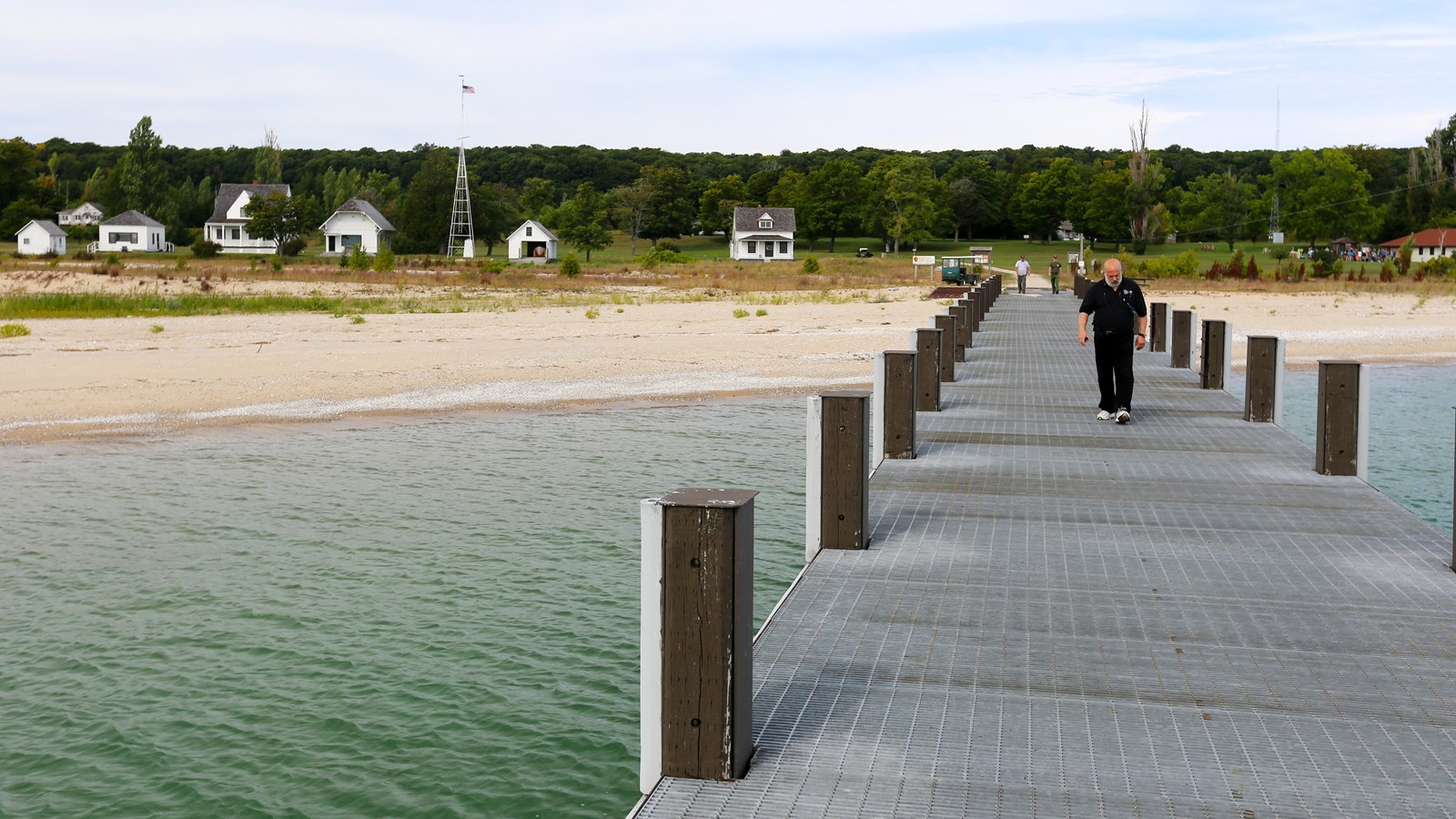 A 10-foot wide and 85-foot-long metal grated dock section extends over the water to the beach