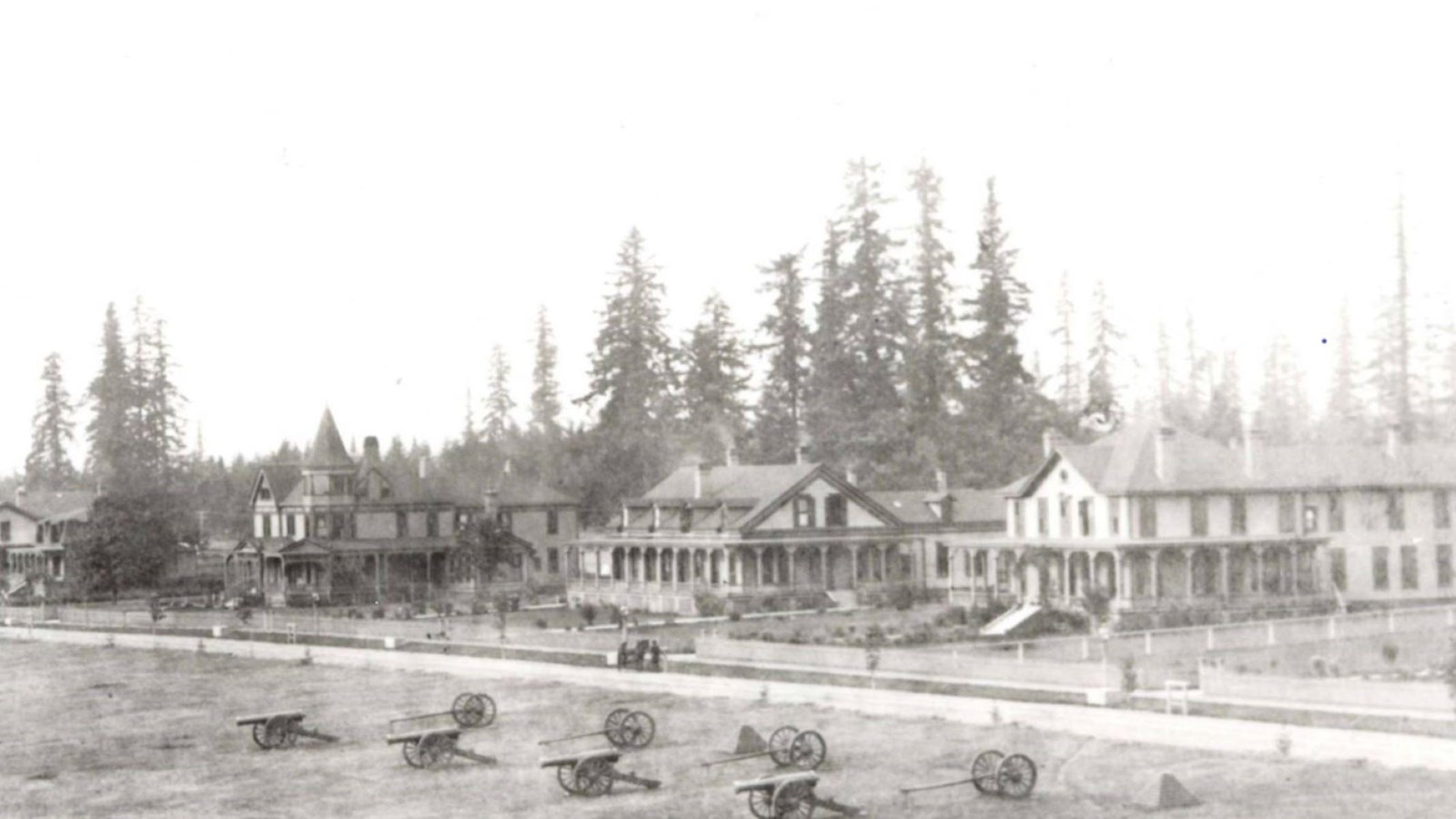 A black and white photo shows a panoramic view of large nineteenth-century homes.