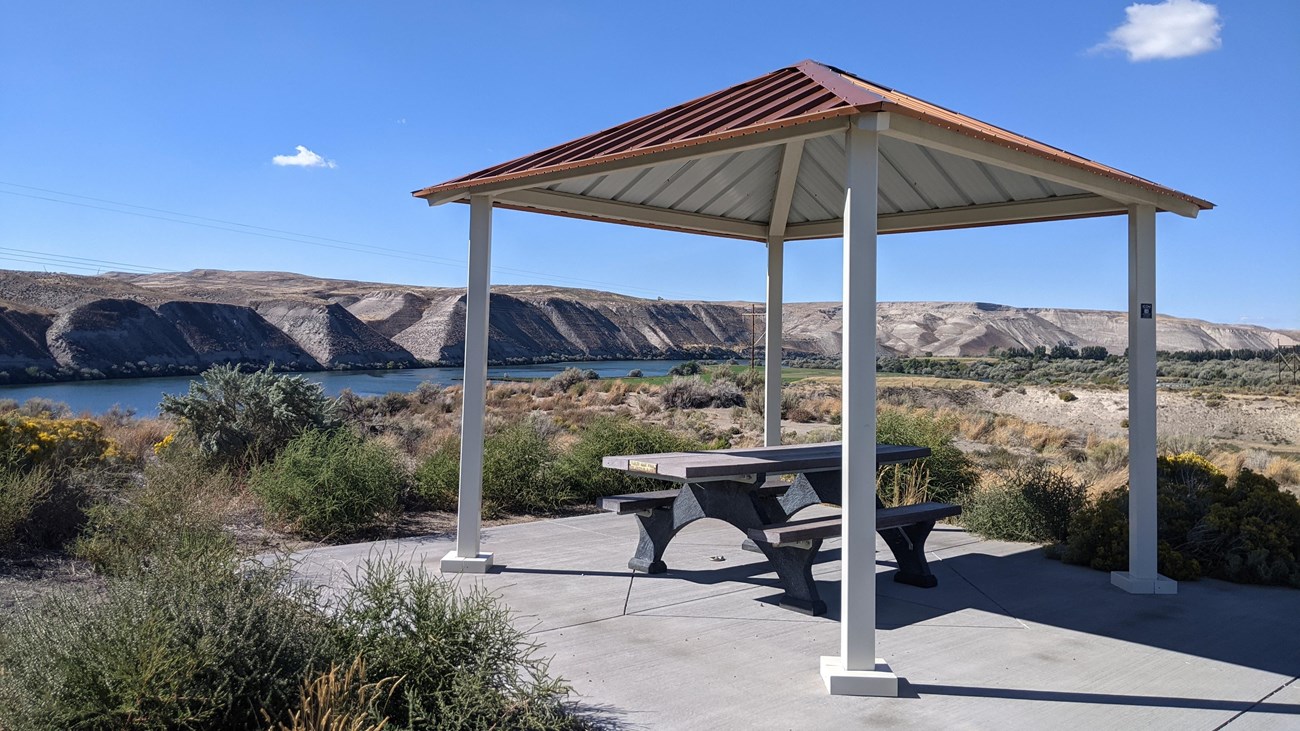 A picnic table under a shelter overlooks the Snake River.