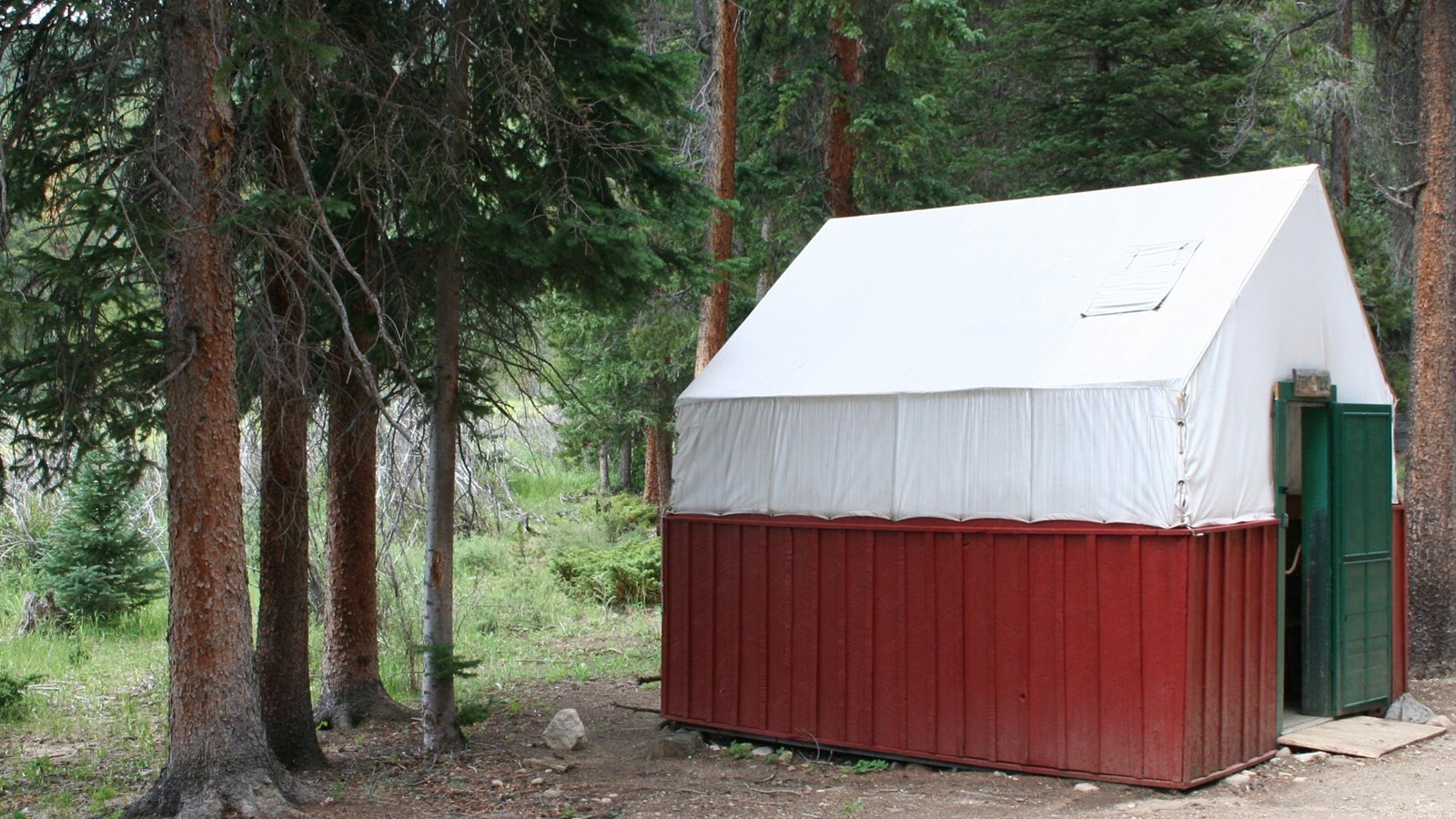 The Tent Cabin is a building with red walls and a white roof.