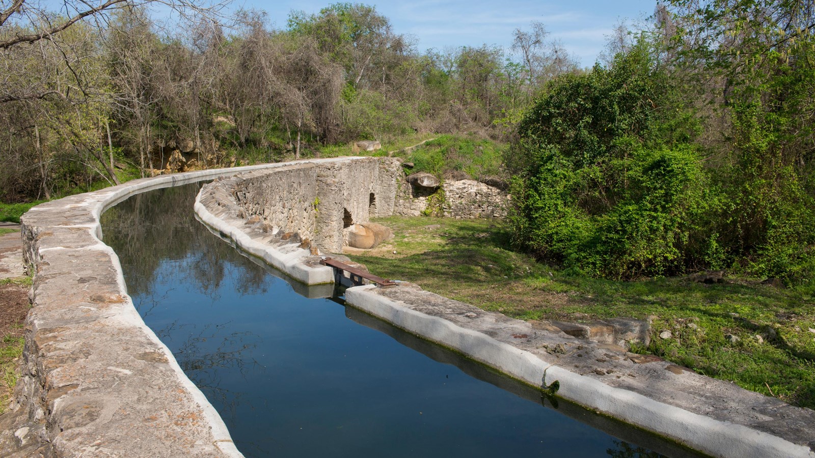 Limestone aqueduct with arches carries water over Six Mile Creek below