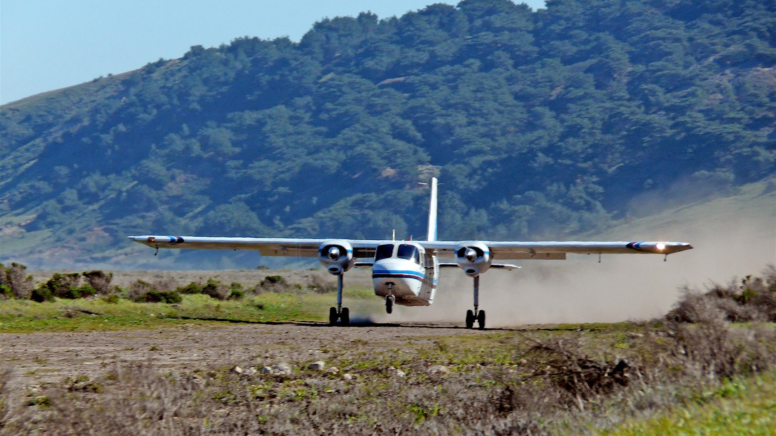 small plan landing on dirt strip.