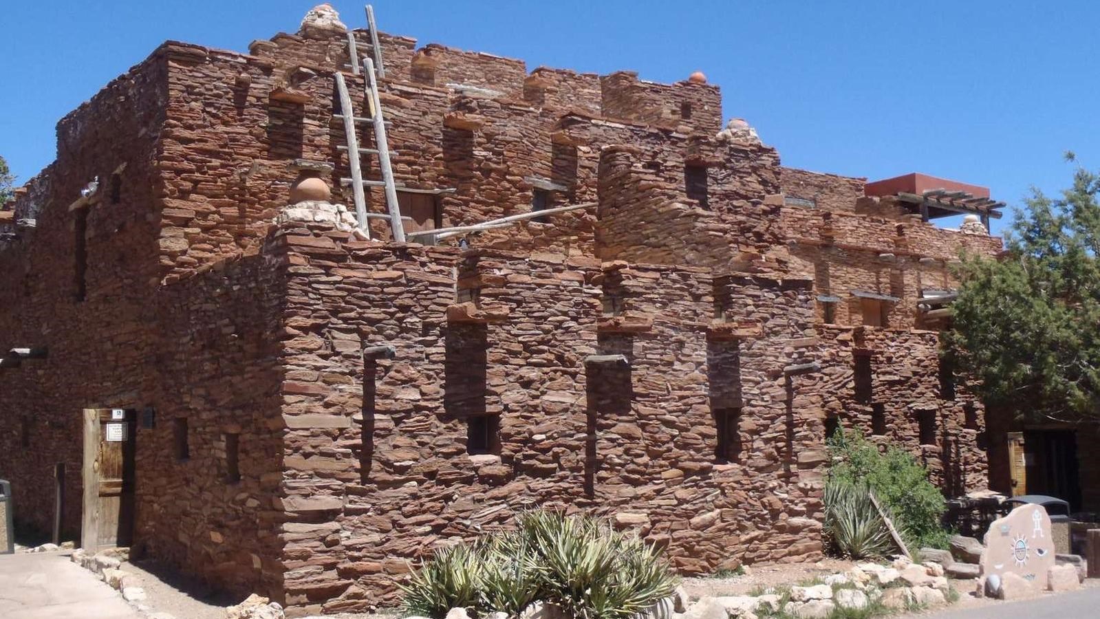 A two story red brick building with southwestern native american elements
