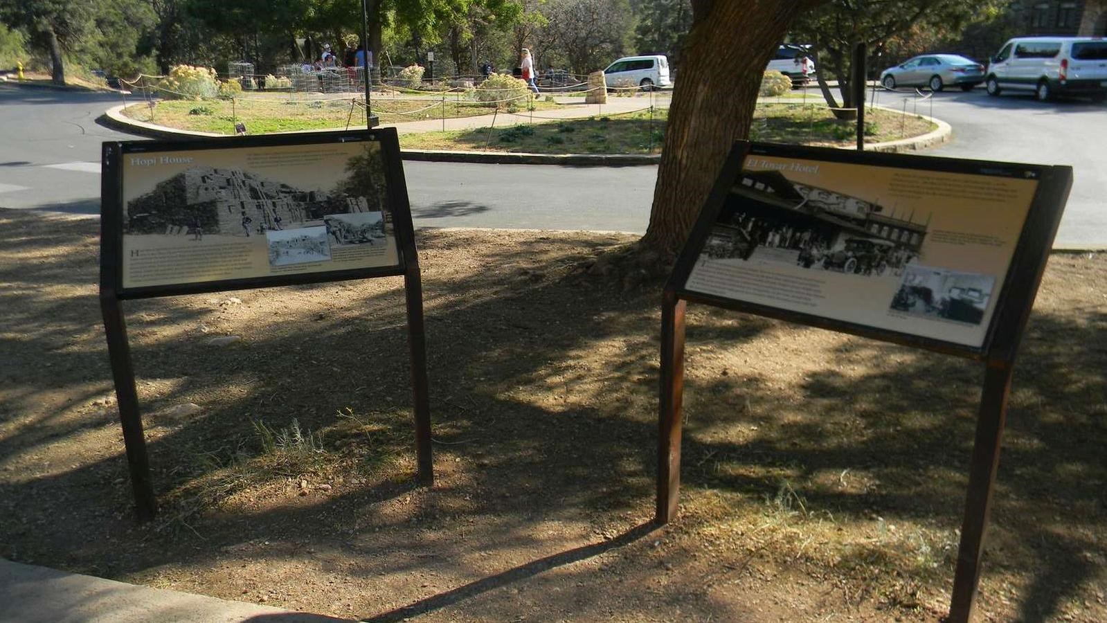 A pair of shaded, angled waysides discuss two of the oldest buildings in Grand Canyon Village.